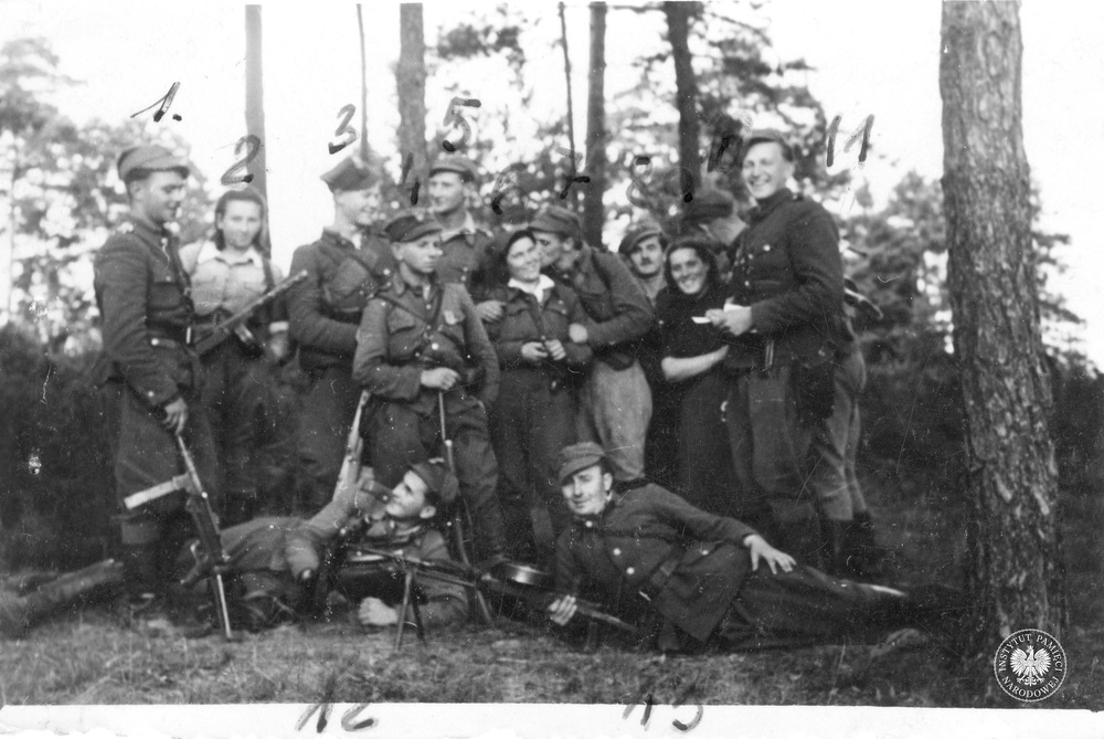 Grupa żołnierzy V Wileńskiej Brygady AK. Stoją od lewej: wachm. Leon Smoleński „Zeus” (nr 1), Danuta Siedzikówna „Inka” (nr 2), „Wieczorek” (nr 3), „Stylowy” (nr 4), „Znicz” (nr 5), Wanda Minkiewicz „Danka” (nr 6), ppor. Zygmunt Badocha „Żelazny” (nr 7), por. Marian Pluciński „Mścisław” (nr 8), sanitariuszka od „Młota” (nr 9), wachm. Jerzy Lejkowski „Szpagat” (nr 10), por. Henryk Wieliczko „Lufa” (nr 11), „Zbigniew” (nr 12), NN (nr 13), wrzesień 1945 r. (IPN BU 024/96)