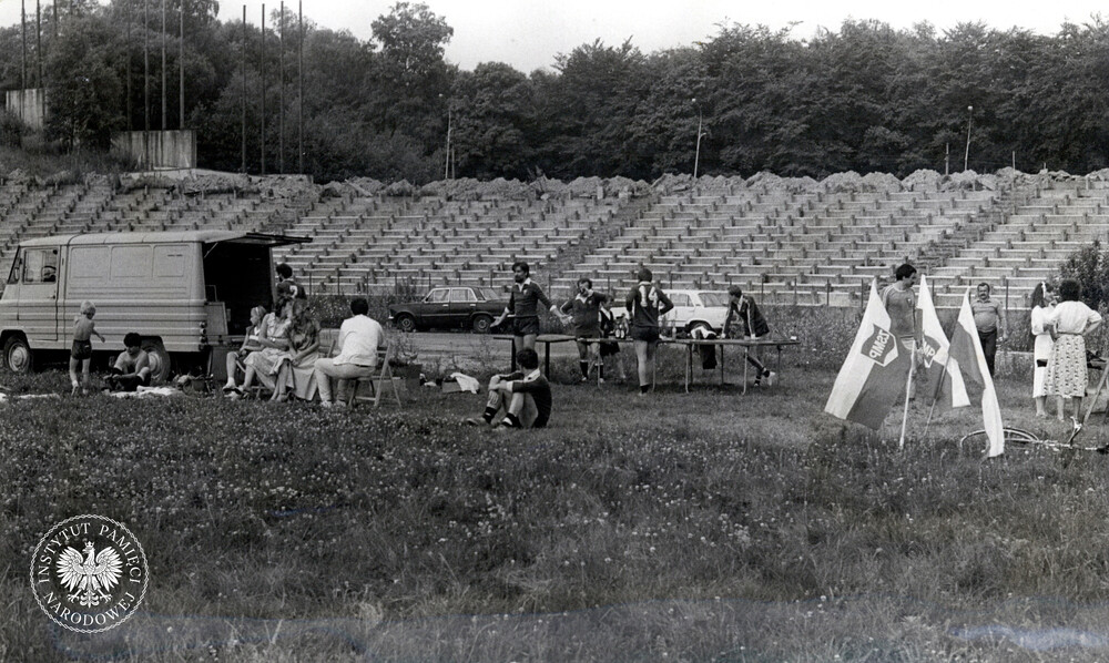 „Sympatyczna impreza” – czyli letni festyn sportowy dla funkcjonariuszy i ich rodzin (jak widać, przy pełnych trybunach ;-)). Mecz rozgrywa reprezentacja Komitetu Zakładowego PZPR w WUSW z ekipą zarządu międzyzakładowego ZSMP, która wygrała; 1985 r. (IPN Ka 425/116)