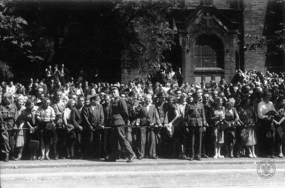 Publiczność podczas defilady w dniu 22 lipca 1953 r. w Katowicach. W tle widoczna jest część południowej fasady ewangelicko-augsburskiego kościoła Zmartwychwstania Pańskiego przy ul. Warszawskiej (IPN Ka 454/51, t. 2)