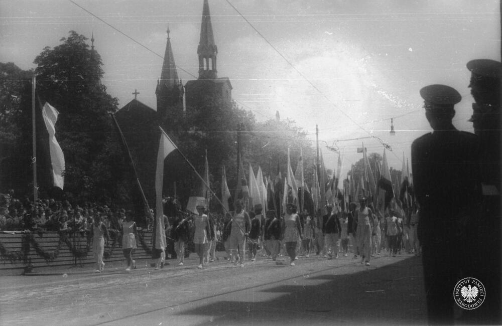 Grupa sportowców podczas defilady w dniu 22 lipca 1953 r. w Katowicach. W tle widoczny jest kościół Zmartwychwstania Pańskiego przy ul. Warszawskiej (IPN Ka 454/51, t. 2)