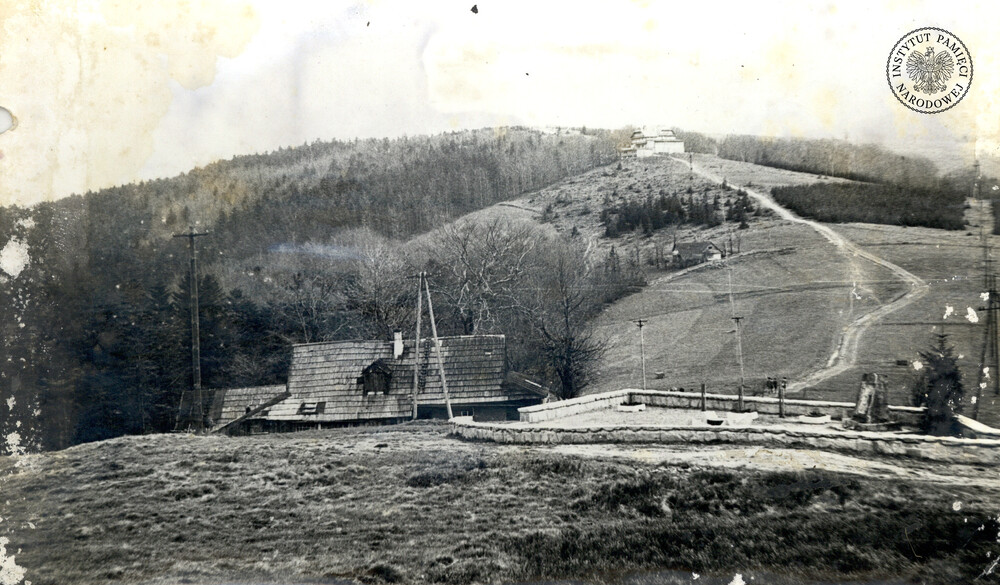 Błatnia, widok w stronę schroniska. Po prawej stronie widoczny jest pomnik, po lewej chatka studencka „Wersal” (IPN Ka 470/6)