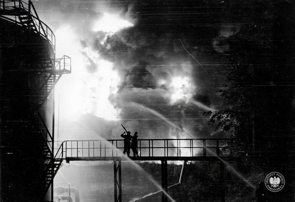 Strażacy gaszący pożar w rafinerii w jego pierwszej fazie, przed katastrofalnym wybuchem. Fotografię wykonano 26 VI 1971 r. między godziną 21 a 24 (IPN Ka 093/299)