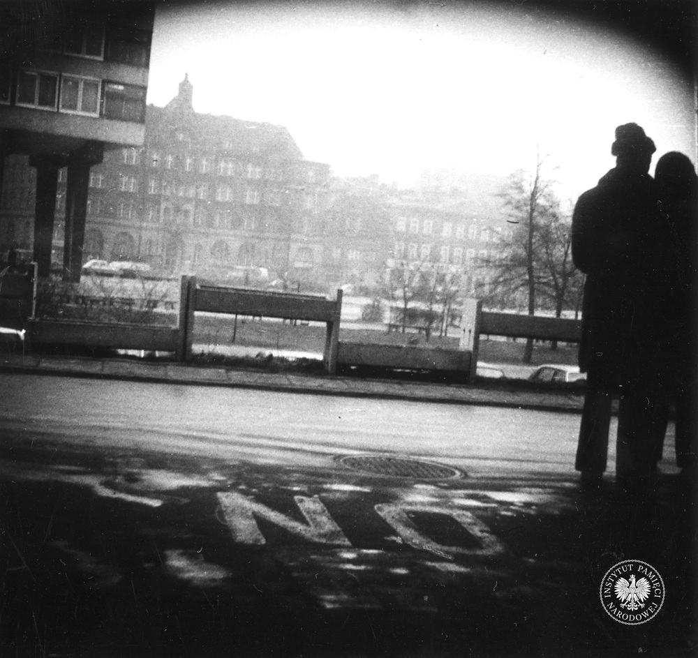 Przykładowa fotografia operacyjna, wykonana z ukrycia podczas obserwacji. Dwie osoby stoją przed nieistniejącym już hotelem „Silesia” w Katowicach. W tle widać m.in. budynek, w którym od 1984 r. mieściło się Muzeum Śląskie. Zdjęcie zrobiono w marcu 1979 r. (IPN Ka 435/12)