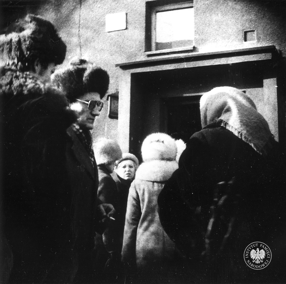 Przykładowa fotografia operacyjna, wykonana z ukrycia podczas obserwacji. Grupa osób stoi przed blokiem, prawdopodobnie w Sosnowcu-Zagórzu. Zdjęcie zrobiono w styczniu 1982 r. (IPN Ka 435/10)