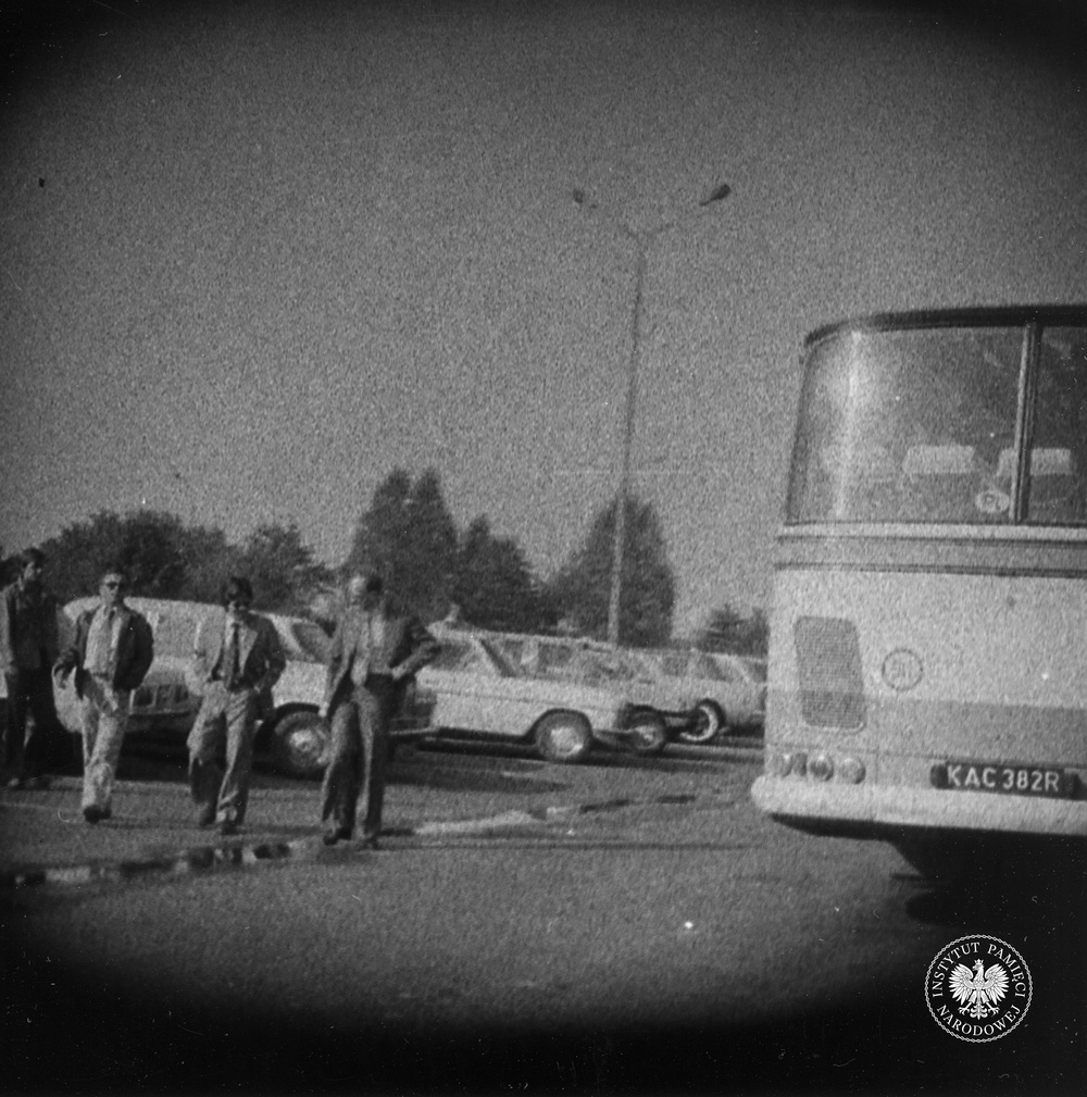 Przykładowa fotografia operacyjna, wykonana z ukrycia podczas obserwacji. Trzej mężczyźni idą przez parking obok portu lotniczego w Pyrzowicach (IPN Ka 435/21)