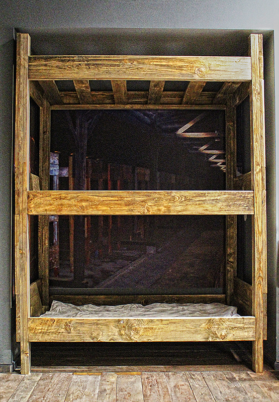 Rekonstrukcja trzypiętrowej pryczy, która była standardowym wyposażeniem baraków dla więźniów